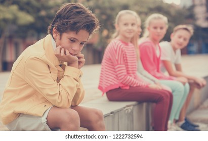 Portrait Of Boy 9-12 Years Old Who Is Taking Offense On His Friends In The Park.