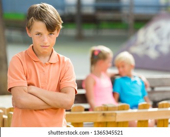 Portrait Of Boy 9-12 Years Old Which Is Taking Offense On His Friends In The Park.