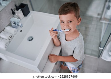 Portrait, boy and brushing teeth in bathroom for dental, development and oral hygiene with toothbrush. Face, child and cleaning mouth in home for healthy gums or learning with toothpaste by mirror - Powered by Shutterstock