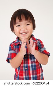 portrait of boy with checker shirt clapping hands