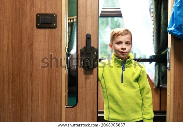 Portrait of boy in\
doorway of train\
compartment