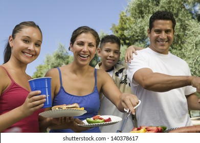 Portrait of a boy with happy family gathered around the grill at picnic - Powered by Shutterstock