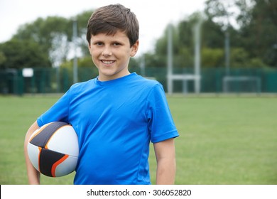 Portrait Of Boy Holding Ball On School Rugby Pitch - Powered by Shutterstock