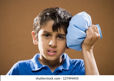 Portrait Of A Boy Holding Ice Pack To His Head