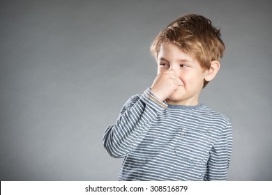 Portrait Of Boy, Holding Nose, Grey Background