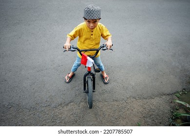 Portrait Of A Boy In Islamic Dress Riding A Bicycle