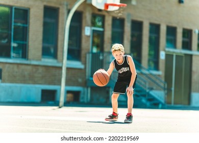 A Portrait Of A Boy Kid Playing With A Basketball In Park