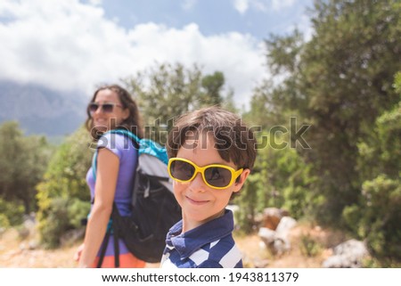 Portrait of a boy with mom on a background of mountains, a woman travels with a child, a girl with a backpack goes on a hike with a child, Traveling with children