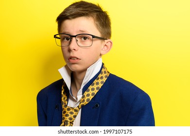 Portrait of a boy on a yellow background with a sad expression, an adult suit on a child. new - Shutterstock ID 1997107175