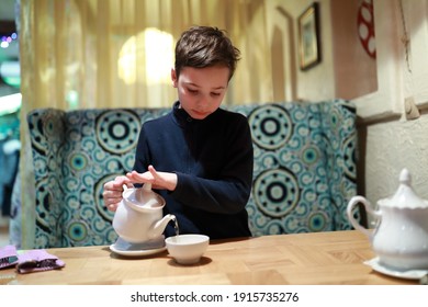 Portrait Of Boy Pouring Tea In Restaurant