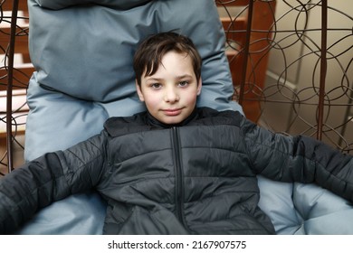 Portrait of boy relaxing in hanging chair - Powered by Shutterstock