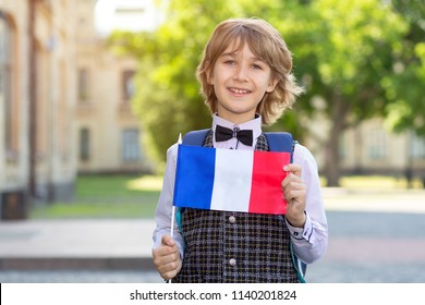 Portrait boy. Schoolboy with the flag of France on the background of the school. The student of college. Learn French. - Powered by Shutterstock