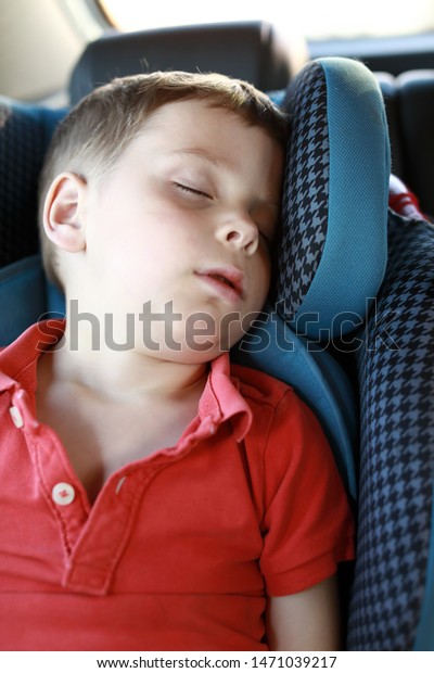Portrait of boy sleeping in\
car seat