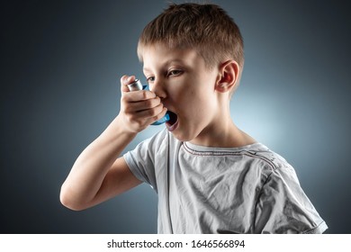 Portrait of a boy using an asthma inhaler to treat inflammatory diseases, shortness of breath. The concept of treatment for cough, allergies, respiratory tract disease - Powered by Shutterstock