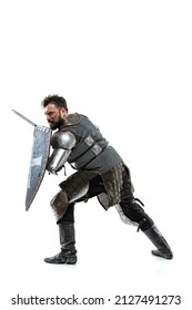 Portrait Of Brave Medieval Warrior, Knight In Special Armor Protecting Himself With Shield And Sword Isolated Over White Studio Backgrond. Comparison Of Eras, History, Renaissance Style Concept