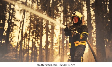 Portrait of a Brave Professional Firefighter Using a Firehose to Fight a Raging Dangerous Forest Fire. Experienced Fireman Skillfully Manages the High-Pressure Water and Stays Safe. Low Angle. - Shutterstock ID 2258645789