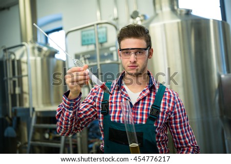 Portrait of brewer testing beer at brewery factory