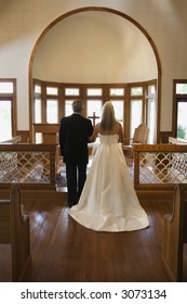 Portrait Of Bride And Groom At Alter Of A Church.