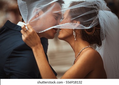retrato de noiva e noivo beijando em um fundo da cidade.