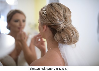 Portrait Of Bride Putting On Make Up . The Bride Putting On Lipstick In Living Room Front Of Mirror