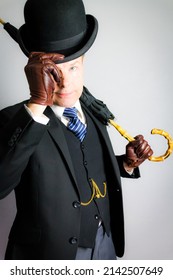 Portrait Of British Businessman In Dark Suit Politely Doffing Bowler Hat. Classic Manners Of Refined English Gentleman.