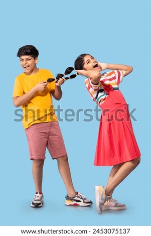 Portrait of brother pulling braid of his sister