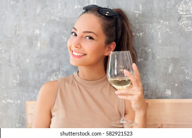 Portrait of a brunette beauty drinking wine.
