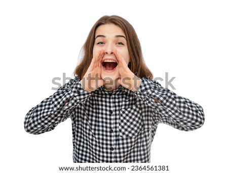 Portrait of brunette eighteen year old girl shouting out loud with hands over mouth, smiling happy at camera, isolated on white background. Adorable girl smile, looks to camera and posing in studio.