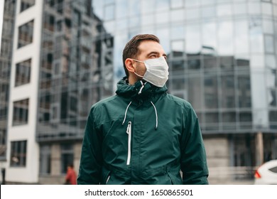 portrait of brunette man in a surgical bandage on a background of a modern building, coronavirus, illness, infection, quarantine, medical mask - Powered by Shutterstock