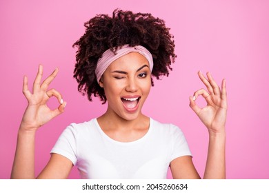 Portrait of brunette optimistic lady show okey sign blink wear white t-shirt hairband isolated on pastel pink background - Powered by Shutterstock