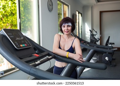 Portrait of a brunette woman in the gym near the simulators. - Shutterstock ID 2250361513