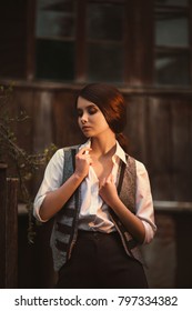 Portrait Brunette Young Girl Retro Hooligan. Woman Is Dressed Like A Man, A Vintage Style. Times Of The Great Depression Fashion Men's Clothing 20s 30s. Clothes Shirt Black Pants, Gray Vest, Pretty 