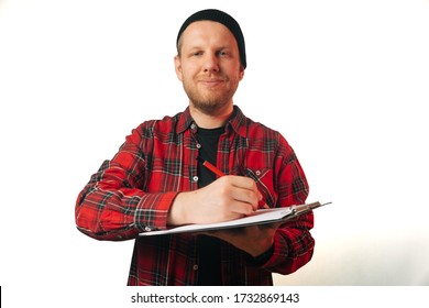 Portrait Of A Brutal Successful Builder, On A Light Background. Average Plan Of A Man In A Plaid Work Shirt. Isolation, Copy Space Next To A Person.