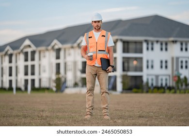Portrait of builder in a construction site. Builder ready to build new house. Construction builder wear building uniform and helmet, builder on buildings construction background.