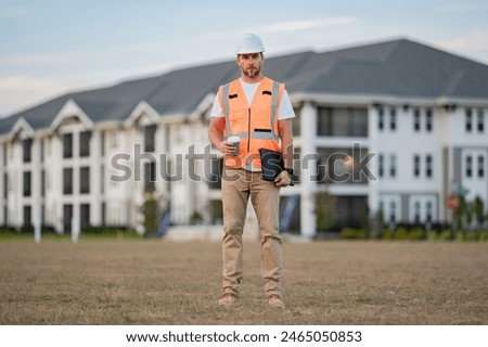 Portrait of builder in a construction site. Builder ready to build new house. Construction builder wear building uniform and helmet, builder on buildings construction background.