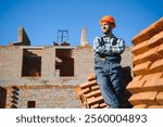 Portrait of a builder in the process of working on a construction site outdoors.