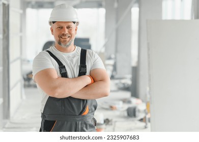 Portrait of a builder in the process of working on a construction site indoors.