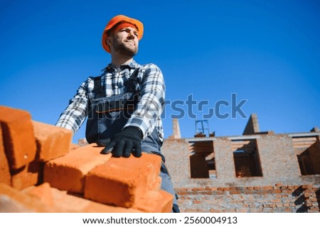 Portrait of a builder in the process of working on a construction site outdoors.