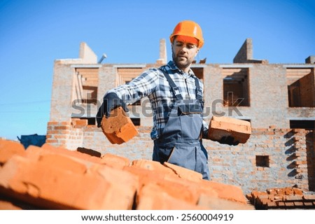 Portrait of a builder in the process of working on a construction site outdoors.