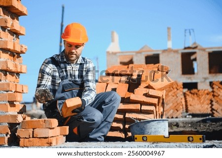 Portrait of a builder in the process of working on a construction site outdoors.