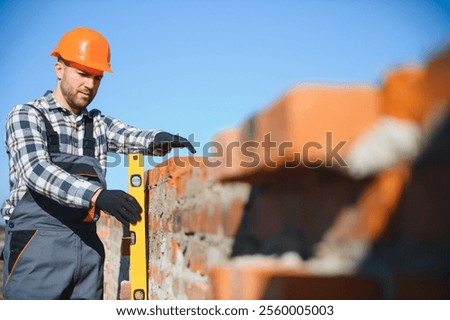 Portrait of a builder in the process of working on a construction site outdoors.