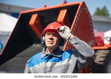 Portrait Bulldozer Driver Industrial Worker Man In Protective Helmet And Headphones Background Factory.