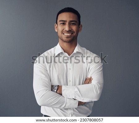 Portrait, business and Asian man with arms crossed, career and confident guy against a studio background. Face, male person and employee with happiness, startup success and professional with a smile