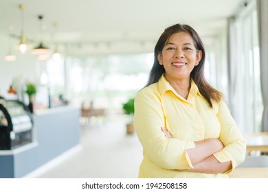 Portrait of business asian woman 60s smile looking camera in restaurant reopen during covid19 coronavirus.Delivery, business Lockdown.Senior indian woman. entrepreneur woman happy with retirement.