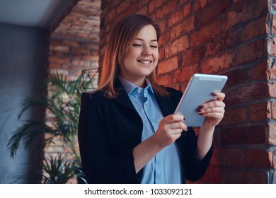 Portrait Of A Business Blonde Woman In A Casual Suit Using A Tab