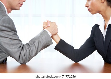 Portrait of business competitors doing arm wrestling and looking into each other?s eyes