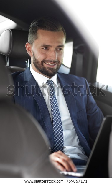 Portrait of a\
business man in the back seat of a\
car