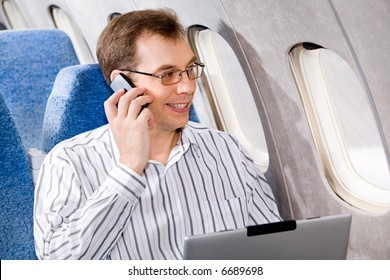 Portrait of business man calling by phone in the airplane - Powered by Shutterstock