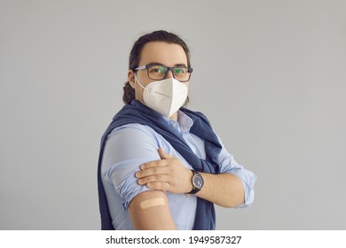 Portrait Of Business Man Promoting Coronavirus Vaccination. Businessman, Office Worker Or Company Employee Wearing Glasses And Face Mask Shows Arm With Adhesive Plaster After Getting Covid 19 Vaccine