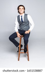 Portrait Of Business Man Sitting On A High Stool And Smiling For The Camera On A White Background